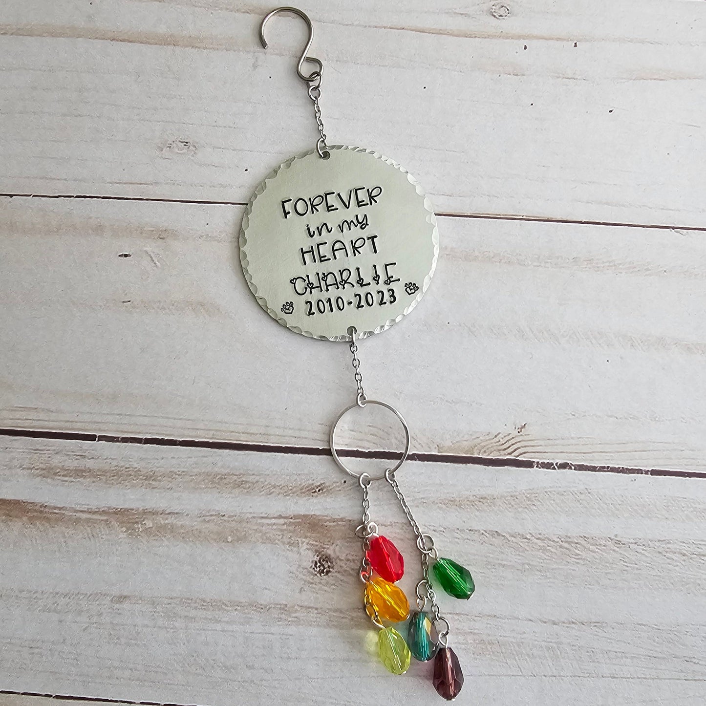 Silver Disc that reads Forever in my heart with pet's name and year. Also includes rainbow colored crystals that hang down