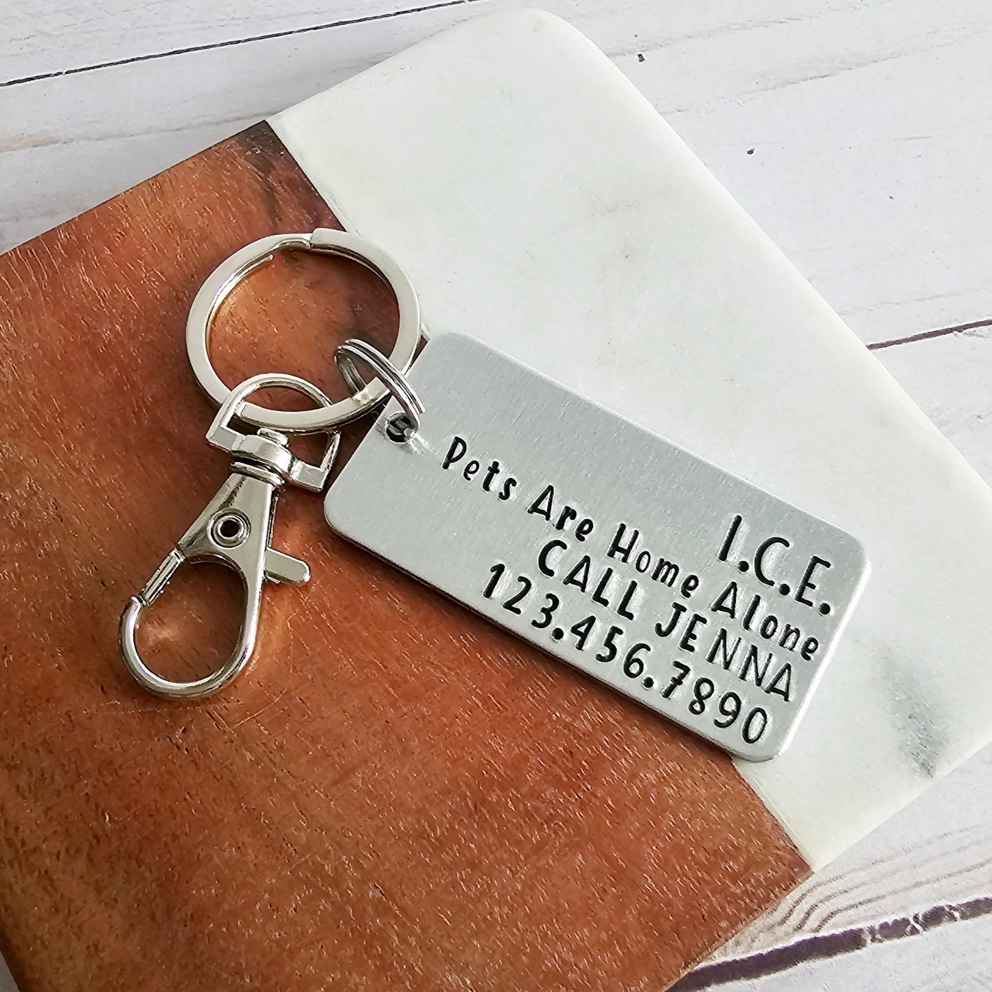 Silver metal keychain that reads ICE Pets Are Home Alone Call (name) and (phone number