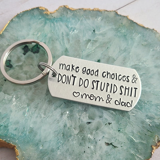 Silver Keychain that is handstamped to read Make good choices & Don't do stupid shit <3 mom & dad