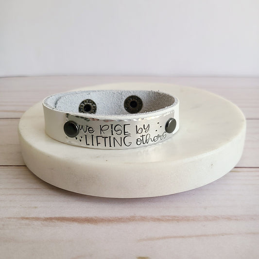We Rise By Lifting Others - White Leather Cuff Bracelet