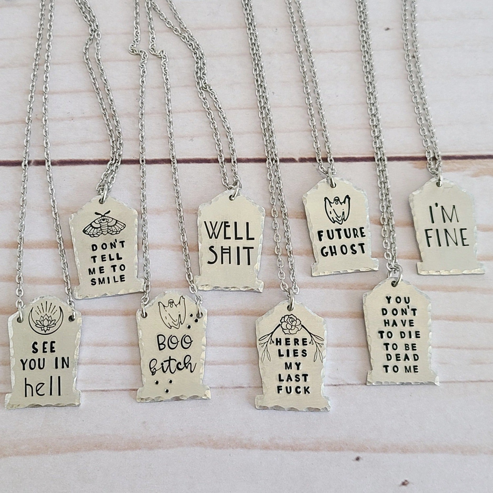 Silver Tombstone Shaped Charms on a necklace chain - the tombstones are stamped with different spooky sayings