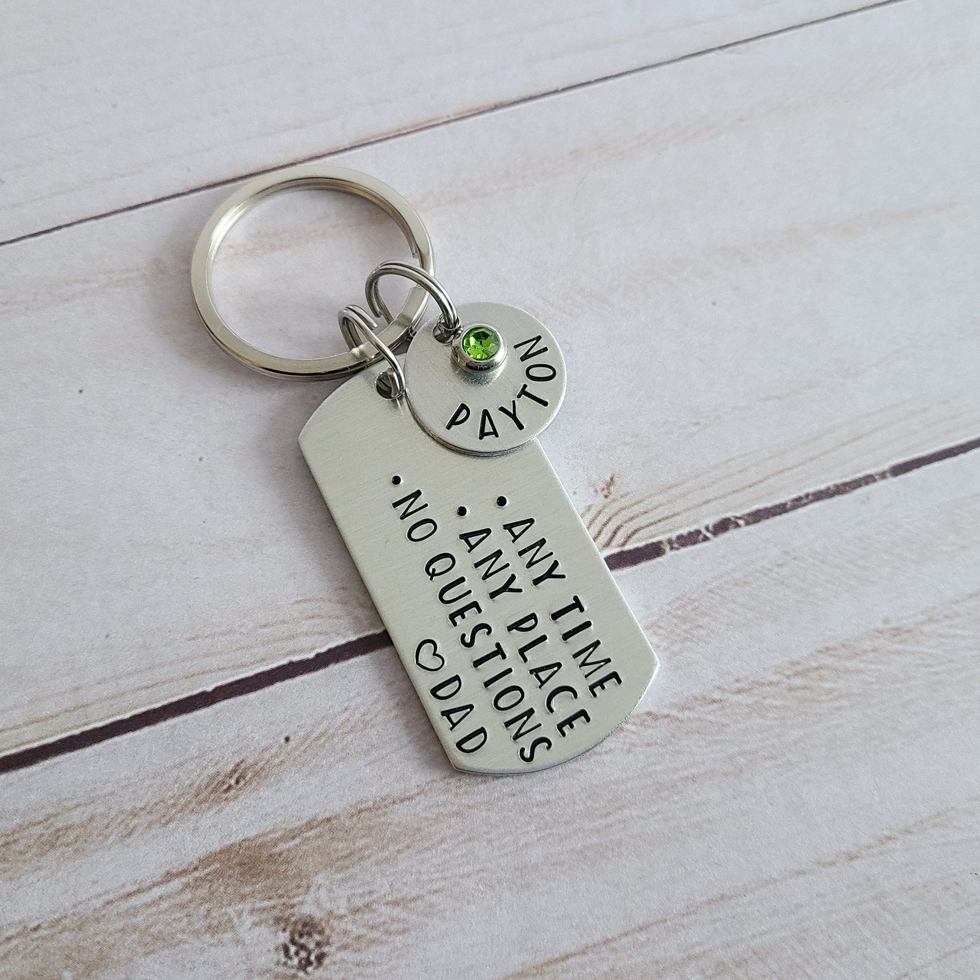 Silver Metal keychain that is hand stamped to read Any Time Any Place No Questions Love Dad